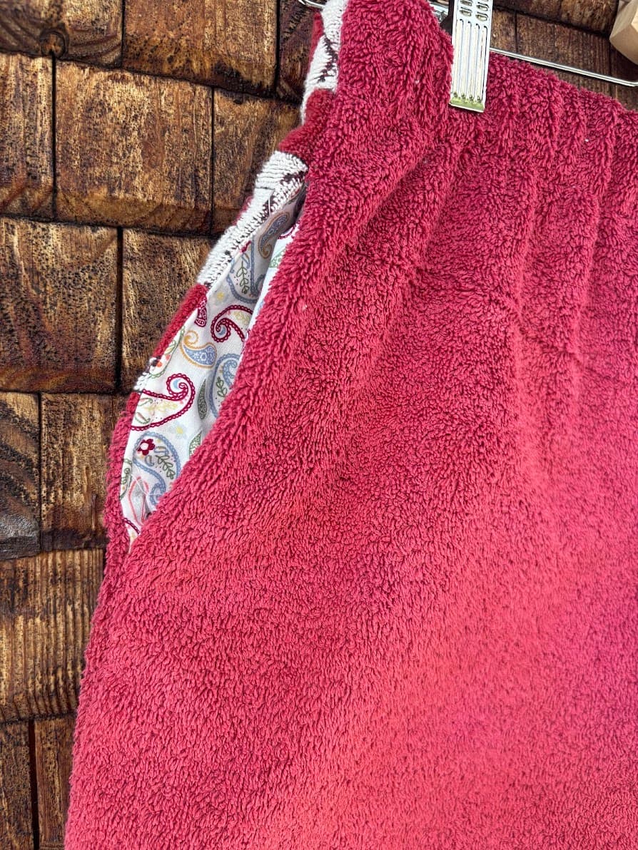 Detailaufnahme der handgefertigten Dusty mosaic '85 Shorts, die den Übergang zwischen dem hochwertigen, magenta-farbenen Frottee und dem geometrisch gemusterten Mosaik-Stoff im Nahtbereich hervorhebt.