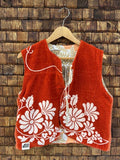 Vorderansicht der gewendeten Frotteeweste 'Laguna' von Old Wave in kräftigem Terrakotta-Orange mit weißer Retro-Blumenbordüre am unterem Saum und Logo-Patch unten links.